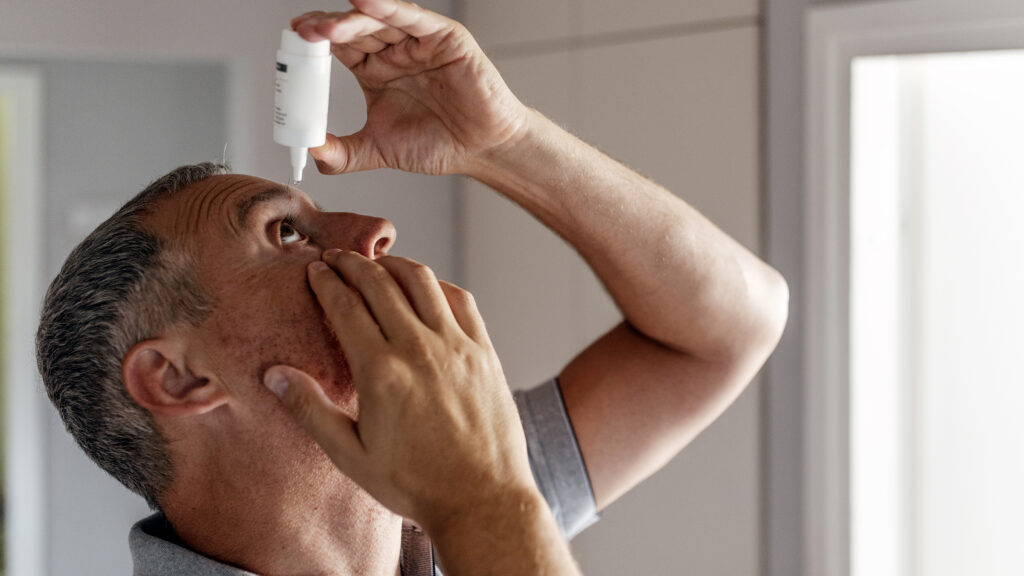 Man putting in eye drops picture.
